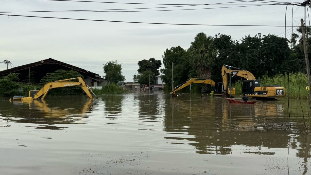 挖掘机帮助抗洪,停在防水堤边,早上几乎完全被淹没