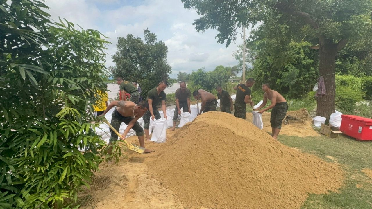 波蓬村民紧张地注视着水位上升，急忙堆放沙袋